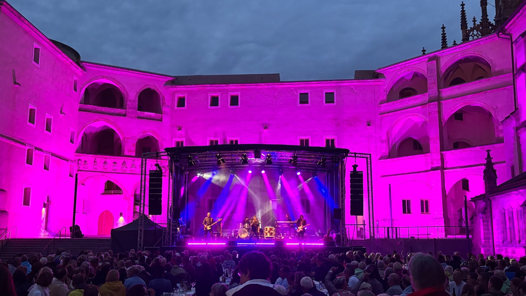 Pink und violett beleuchtete Konzertbühne im Innenhof
